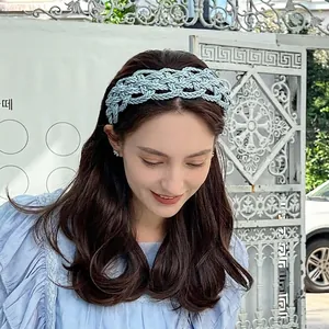 Light blue braided wide headband with hollow texture on model in outdoor setting
