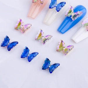 Detailed macro view of 3D crystal butterfly nail charms with aurora purple and blue facets