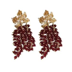French vintage gold leaf and red grape bead long tassel earrings on a white background