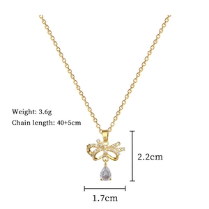 Macro detail of gold bow and teardrop necklace with crystal dimensions and weight info