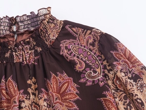 Detail of high neck smocked collar with paisley print on purple chiffon dress