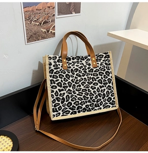 Detail view of linen leopard print tote bag with brown leather handles and shoulder strap