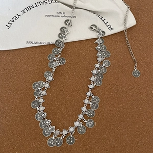 Detail of bohemian silver coin chain with embossed patterns and adjustable lobster clasp