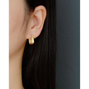 Close-up of minimalist double-layer gold square huggie hoop earrings worn by a model