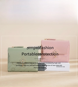 Detail of pink and green quilted wallets with floral metal clasps and textured leather finish