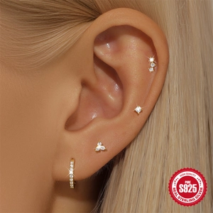 Set of gold S925 sterling silver geometric earrings with zircon inlays on model's ear