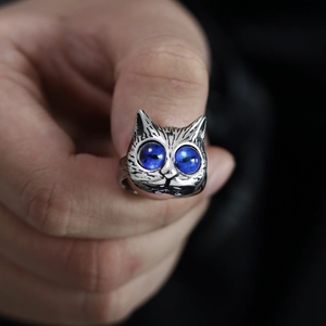 Vintage silver cat ring with blue gemstone eyes featuring detailed fur texture on hand