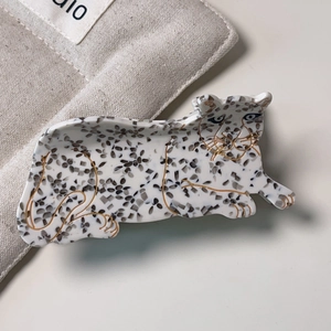 Dettaglio molletta per capelli a leopardo in acetato con rifiniture dorate lucide