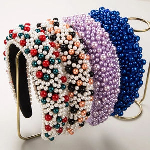 Détail de quatre serre-têtes rembourrés avec perles colorées sur un support doré élégant