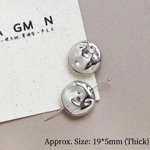 Dettaglio di perle metalliche argentate da 19mm con trama martellata per gioielli DIY