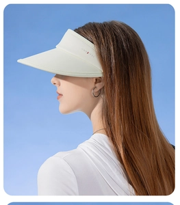 Side view of beige open-top sun hat with wide brim against blue sky background