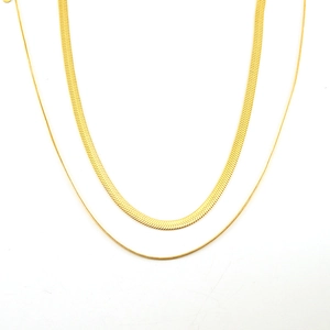 Detailed top view of double-layered gold snake bone necklaces in thick and thin styles