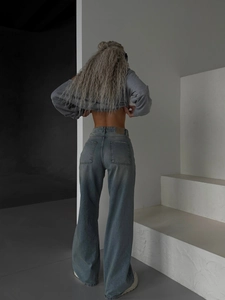 Jean flare taille haute bleu délavé avec sweat court gris dans un style studio