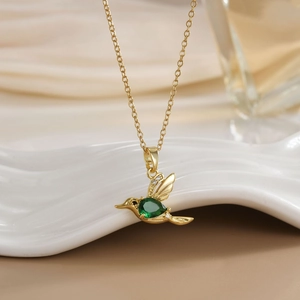 Elegant gold-plated hummingbird necklace with green gemstone and white zircon accents