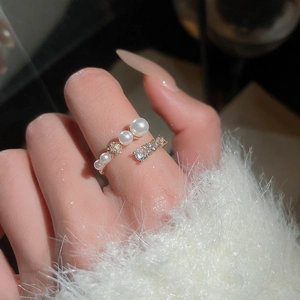 Detail of adjustable gold-plated ring featuring tiered pearls and sparkling cubic zirconia