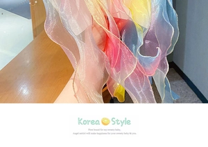 Close-up of rainbow gradient hair ribbon with golden edges and organza texture