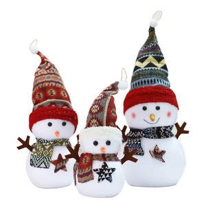 Three plush snowman figurines with ethnic hats for Christmas holiday window display