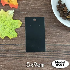 Matte black jewelry display card 5x9cm on wood surface with maple leaf decoration