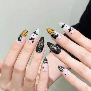 Halloween press-on nails featuring pumpkin, bat, and spider web designs on long almond shape
