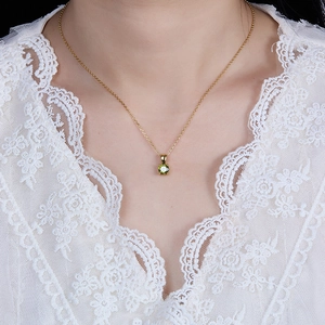 Close-up of a 925 sterling silver gold-plated necklace with a green zircon birthstone