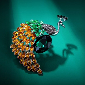 Macro shot of peacock brooch with emerald green crystal and grey pave rhinestones