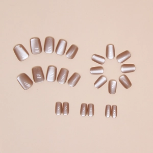 Détail de faux ongles œil de chat or rose avec une finition magnétique à paillettes