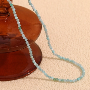 Detailed view of faceted light blue amazonite beads on 18K gold plated necklace