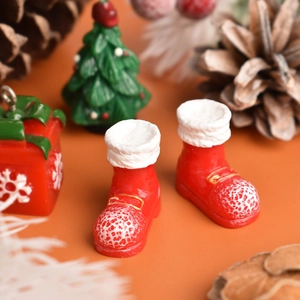 Close-up of miniature red and white resin Christmas boots on festive background