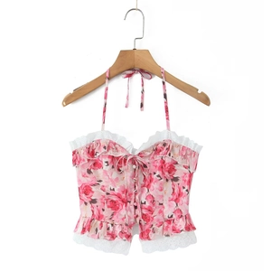Detail van de roze gebloemde haltertops met witte kanten rand en strik aan de voorkant