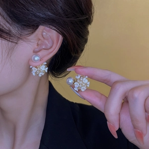Vue détaillée de boucles d'oreilles fleurs en perles avec pétales blancs et billes dorées