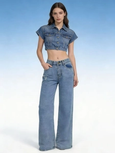 Détail d'un ensemble jean taille haute à jambe large et veste en denim bleue assortie