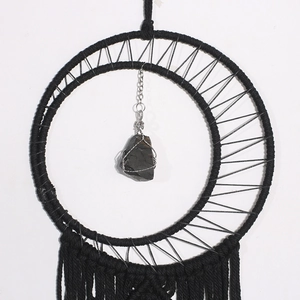 Detail of hand-woven moon dream catcher with black cotton rope and obsidian stone