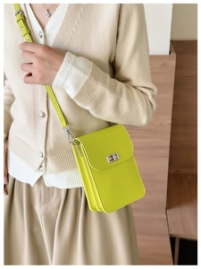 Detail of neon green mini crossbody bag with leather texture shown on model side profile