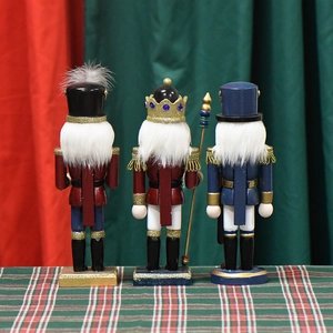 Three 25cm pink glitter nutcracker dolls with crowns on festive plaid background