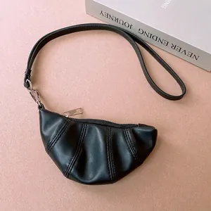 Minimalist black faux leather croissant bag necklace with a sleek metal zipper detail
