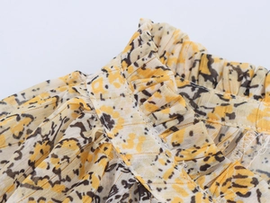 Detailed view of yellow floral chiffon shirt neckline with refined pleats and stitching