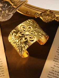 Detail eines böhmischen Goldarmbands mit Vintage-Blumenmuster auf Samthintergrund