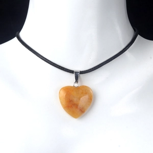 Natural yellow stone heart pendant necklace with black cord on mannequin