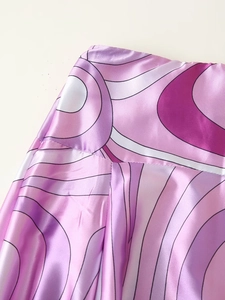 Detailaufnahme des violetten Wellenmusters auf glänzendem Satinstoff mit Textur