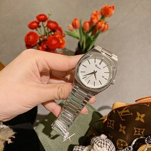 Detail view of a silver square watch featuring a white dial, date display, and steel strap