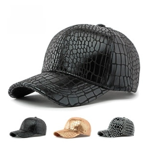 Detail of baseball cap showing embossed crocodile texture and glossy PU leather material