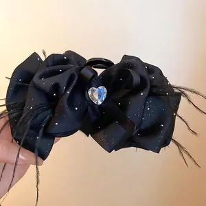 Elegant black satin bow hair claw with heart rhinestone and feather accents for women