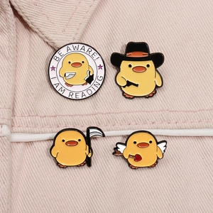 Détails de quatre pin's canard en émail avec motifs Faucheuse et Cupidon sur tissu