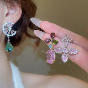 Detailed close-up of earrings featuring colorful cubic zirconia drops and silver needle studs
