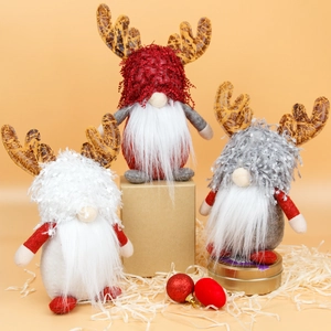 Three Christmas gnomes with reindeer antlers and long white beards on warm background