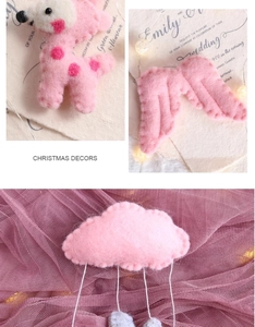 Detail of handmade pink wool felt Christmas ornaments in deer, wing, and cloud shapes