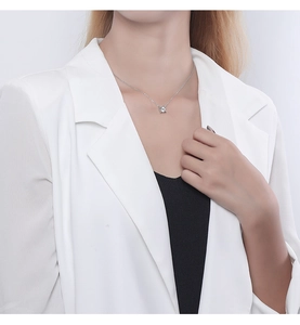 Close-up of minimalist S925 silver necklace with zircon pendant worn on a female neck