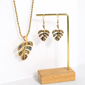 Detail of Monstera leaf jewelry set with natural abalone shell and gold metal finish