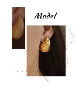 Detail view of 18K gold plated teardrop earrings with hammered texture on model