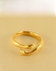 Detailed macro view of an 18k gold plated stainless steel hugging hands open ring